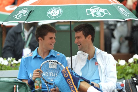 Serbia's Novak Djokovic (right) shares a laugh with a ball boy during his first-round match during a rain delay. Photo: AFP