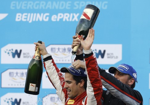 Lucas di Grassi of Brazil (left) is doused with champagne by second placed Franck Montagny of France after winning the Beijing leg of the Formula E circuit. Photo: AP