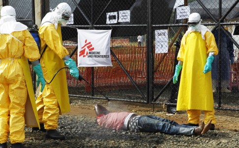 Liberian nurses disinfect the body of a suspected Ebola victim at the entrance of the Medicins Sans Frontiers (MSF) Ebola treatment center in Monrovia, Liberia. Photo: EPA