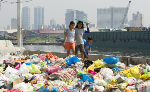 Filipinos walk among trash at a dike in Manila, the Philippines. Countries and organizations began to announce measures to reduce greenhouse gas emissions and divest in fossil fuels on the one-day UN Climate Summit, where more pledges to reduce climate change are expected. Photo: EPA