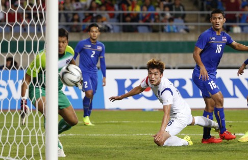 South Korea's Lee Jong-ho (white) scores a goal against Thailand's Kawin Thamsatchanan (left) during their men's semi-final soccer match. Photo: Reuters