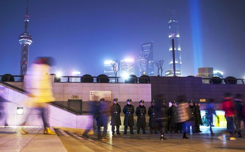 Paramilitary police officers stand guard on the location where people were killed in a stampede incident during a New Year's celebration on the Bund in Shanghai January 1, 2015. Photo: Reuters