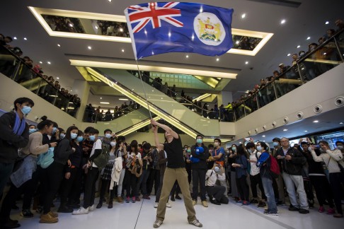 Protester waves a colonial Hong Kong flag during the demonstration. Photo: Reuters