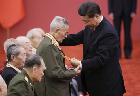 President Xi Jinping and a second world war veteran look at a commemorative medal at a medal ceremony at the Great Hall of the People in Beijing. Photo: Reuters