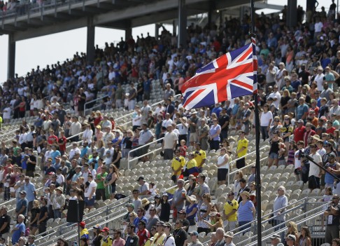 Spectators stand during a tribute to Justin Wilson before the IndyCar Grand Prix of Sonoma.