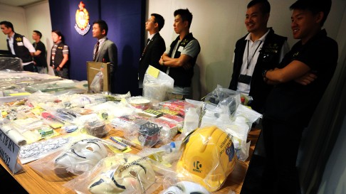 Police display material including Guy Fawkes masks seized in raids in June. Photo: David Wong