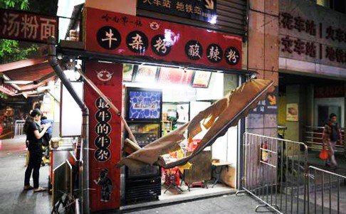 The man broke the awning of the food stall and landed on top of the woman, who was eating outside. Photo: Southern Metropolis News