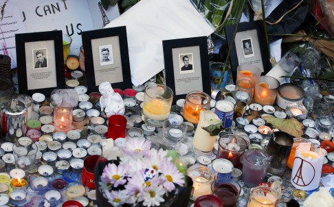 Pictures of victims are placed behind candles  outside the Bataclan concert hall in Paris. Photo: AP