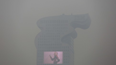 A building and a large screen are seen through tick smog in Beijing. Photo: Reuters