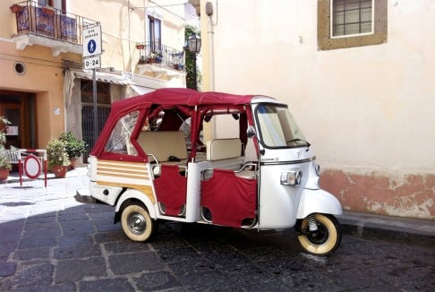 Visitors can catch a ride on a traditional tuk-tuk scooter in an old village in Sicily.